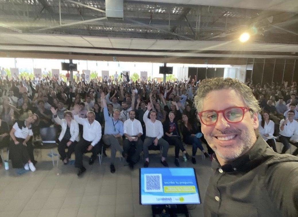 Selfie de Guillermo con un auditorio lleno levantando la mano