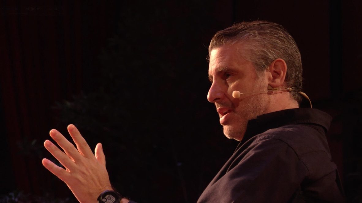 Guillermo explicando en escenario con micrófono de diadema