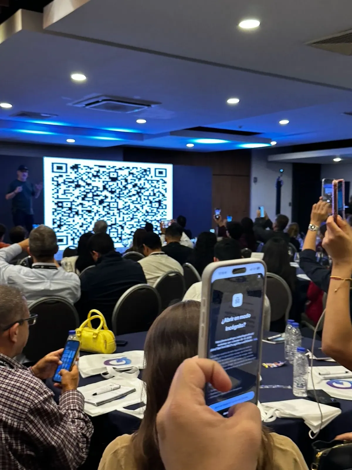 La sala escanea el código QR proyectado en la pantalla gigante